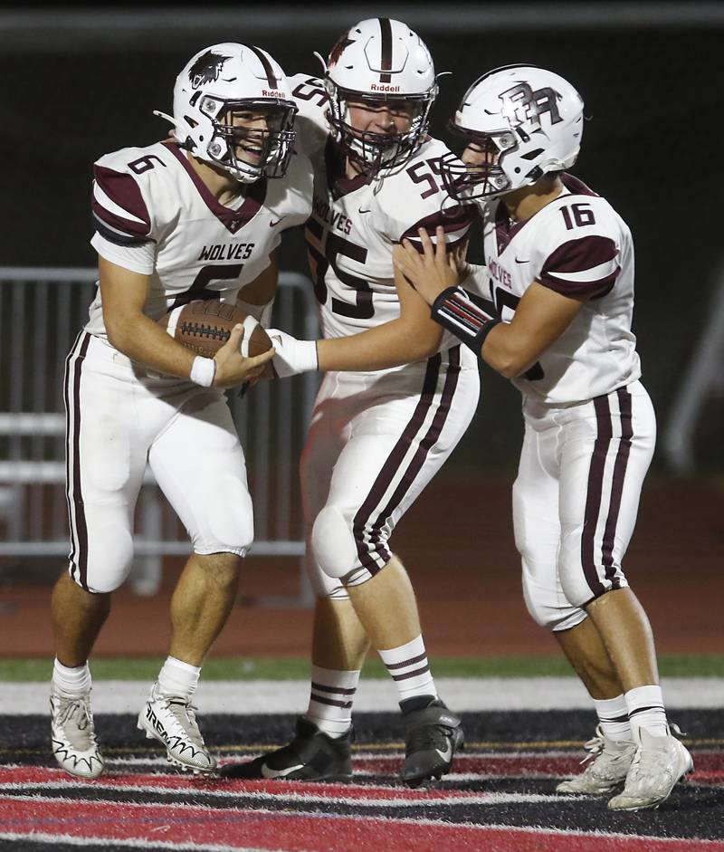 Prairie Ridge's Luke Vanderwiel celebrates a touchdown \with teammates, Braeden Kehl and Samuel Ramirez, during a Fox Valley Conference football game against Huntley on Friday, Oct. 3, 2025, at Huntley High School.