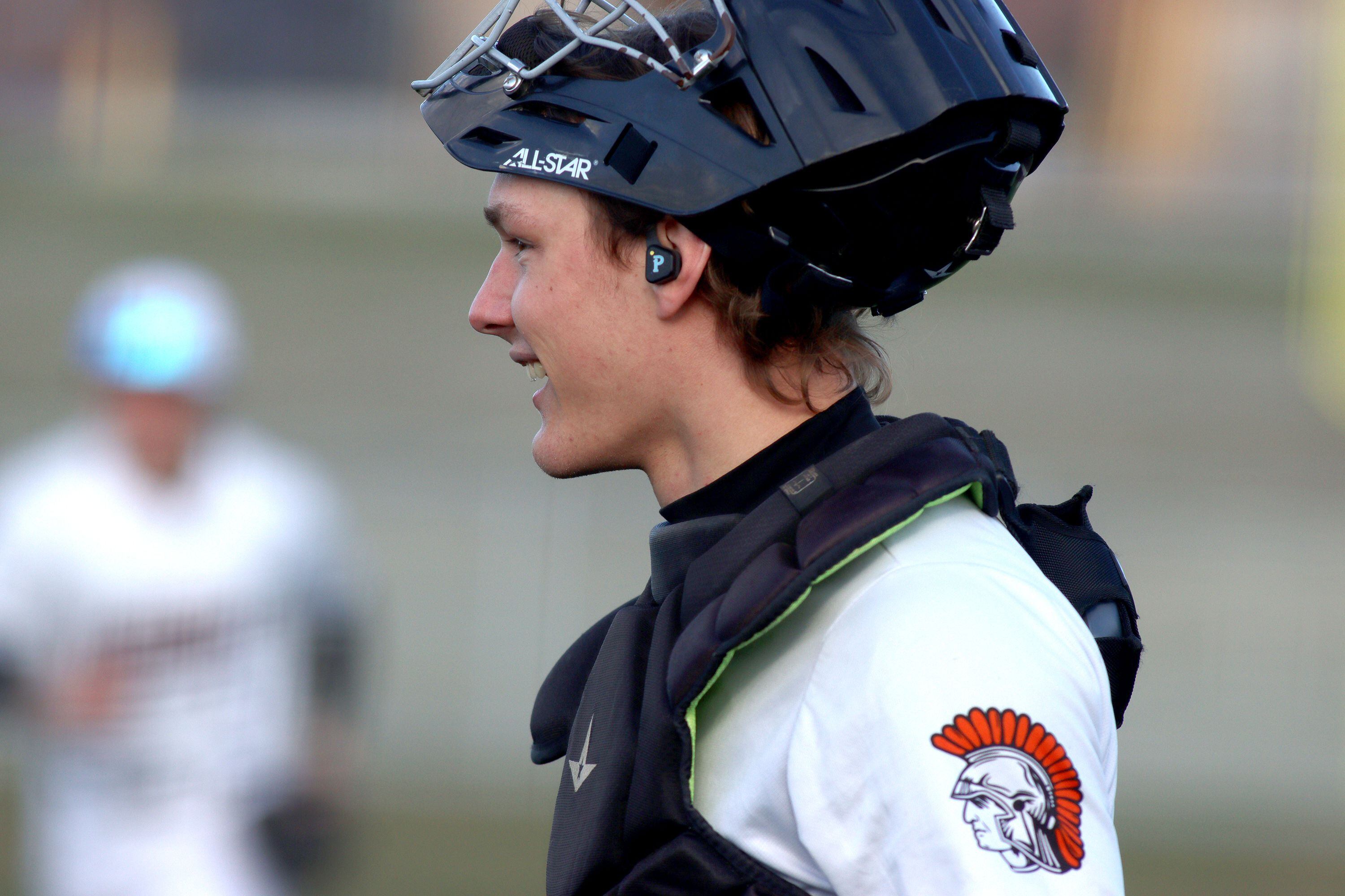 McHenry catcher Kamrin Borck receives pitch calls via earpiece from pitching coach Zach Badgley on April 5 against Huntley.