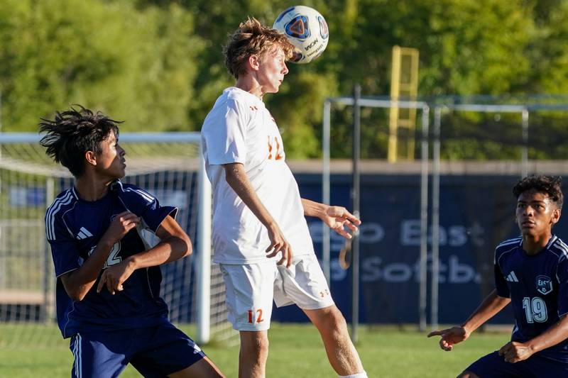 Oswego’s Vilius Adulcikas (center) goes up for a header against Oswego East's Ryan Brandt (left) and Oswego East's Isaac Ruiz (right) during a Southwest Prairie Conference game at Oswego East High School on Thursday, Sept. 25, 2025.