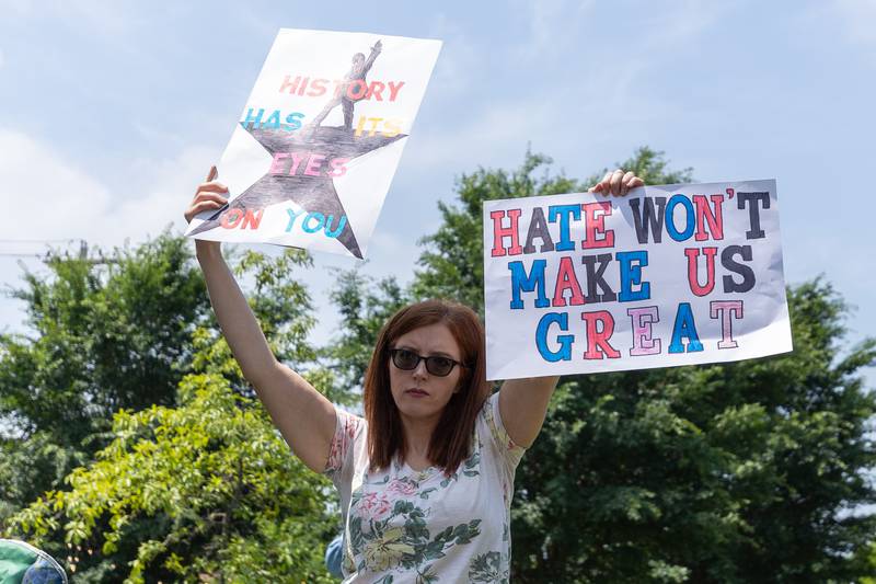 Protester holds signs at the “No Kings” protest on Saturday, June 14, 2025 at Rotary Park in Princeton.
