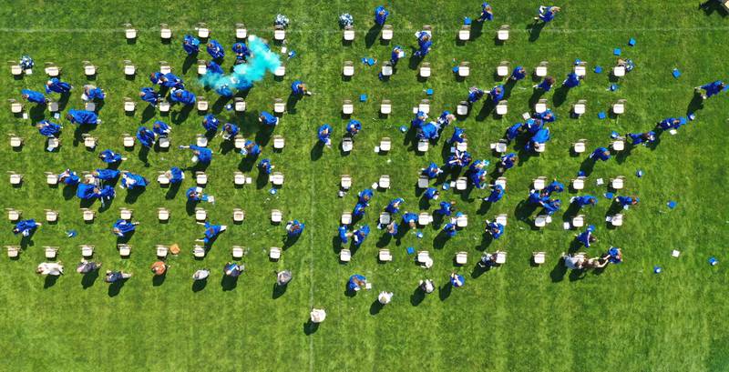 Blue smoke, caps and streamers cover the ground at the conclusion of the graduation ceremony on Saturday, May 20, 2023 in Princeton.