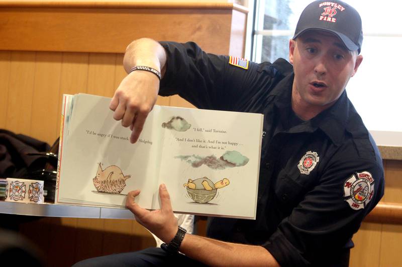 Huntley firefighter Brad DeRaedt reads a storybook during a Read & Eat Fries With a Firefighter event  Thursday, March 16, 2023, at the Culver’s in Huntley.