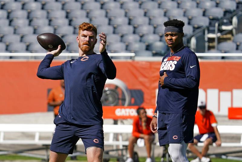 Chicago Bears quarterback Andy Dalton, left, looks to pass as quarterback Justin Fields watches as they warm up before a preseason game against the Miami Dolphins in Chicago on Saturday, Aug. 14, 2021.