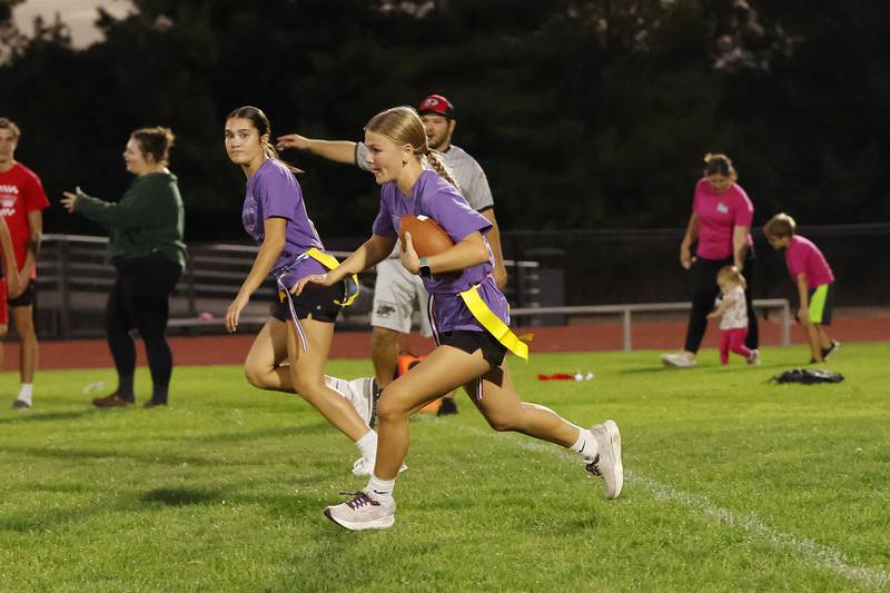 Erie sophomore Kaycee Russell runs alongside teammate Faith Baar during the EHS flag football Powder Puff game against the EHS freshman class on Wednesday, Oct. 1, 2025, in Erie. As part of the EHS homecoming week of festivities, the girls of each class (Freshman, Sophomore, Junior and Senior) compete to see which class will win the trophy. The Seniors took the trophy this year.
