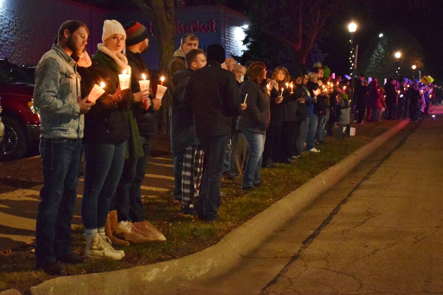 community members lined the streets of downtown Sterling with candles and American flags during a procession honoring Lt. Garrett Ramos