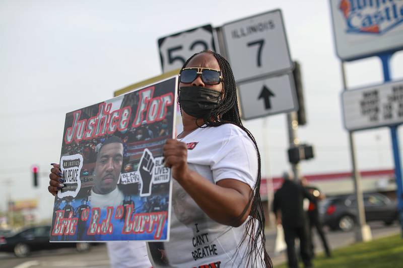 Nicole Lurry, widow of Eric Lurry, the Joliet man who died of an overdose in police custody, holds a sign calling for justice on Tuesday, April 27, 2021, at the corner of Larkin Ave. and Jefferson st. in Joliet, Ill.