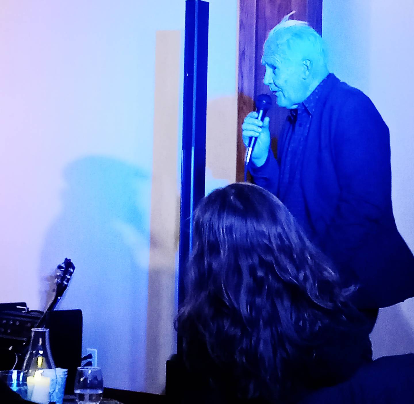 Mark Kelly Smith recites a poem during one of songs of Marques Morel (in shadow) during the Jan. 30 Live Music at the Museum concert series at the Savanna Museum and Cultural Center.