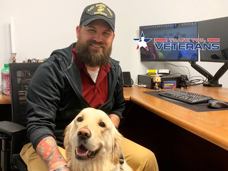Ty Watson, a Veteran Services Officer with the Veterans Assistance Commission of Kankakee County's , poses for a photo with his 3-year-old therapy dog, Maverick, a golden retriever, at the Bourbonnais office.