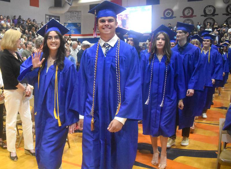 Zoe Wellman (left) and John Swineheart make their entrance Saturday, May 17, 2025, during Genoa-Kingston High School graduation at the school.