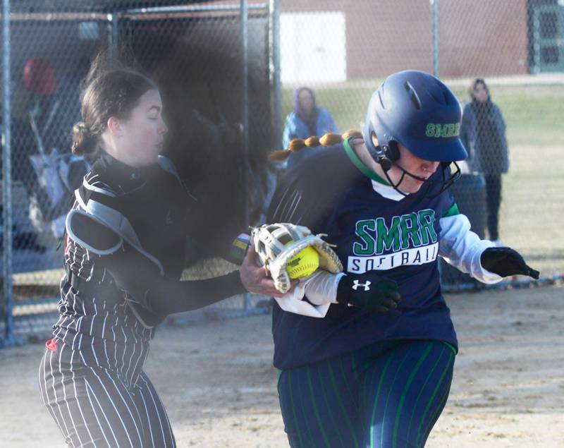 Forreston catcher Maddie Chesnek tags a River Ridge/Scales Mound player as she crosses the home plate on Monday, March 24, 2025 in Forreston. The Cardinals lost the game 8-4,