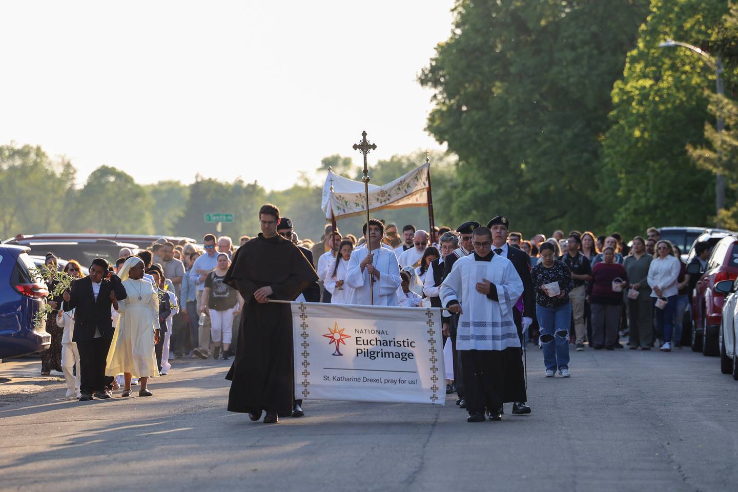 Hundreds walk in the procession as the Eucharist in the monstrance is carried around St. John Paul II parish grounds during the National Eucharistic Pilgrimage stop in Kankakee on Sunday, May 18, 2025.