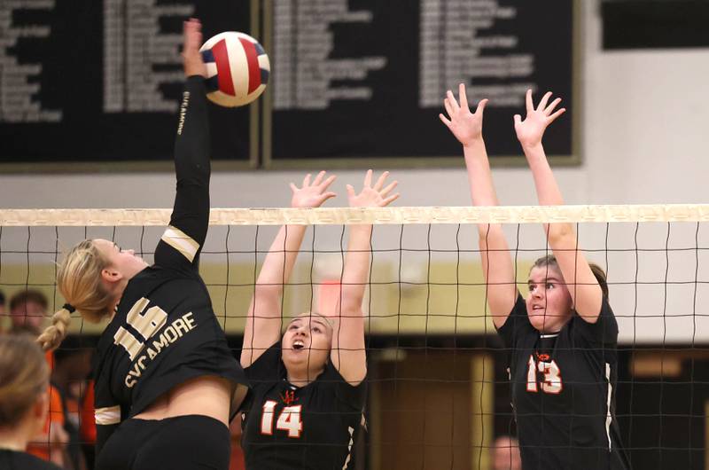 DeKalb’s Brooklynn Siebrasse (left) and Isabella Holiday try to block Sycamore's Jaycie Funderburg during their match Monday, Oct. 16, 2023, at Sycamore High School.