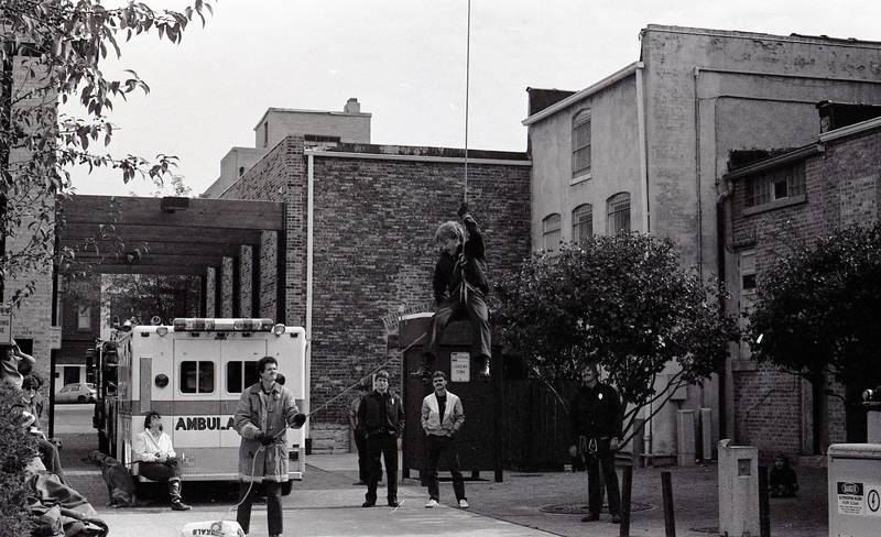 In October 1986, DeKalb Fire Department celebrates Fire Prevention Week with a demonstration, rappelling from the bucket of snorkel number one, in the alley north of Lincoln Highway in DeKalb between Second and Third streets.
