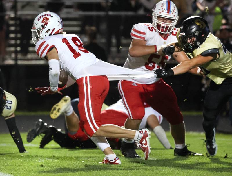 Sycamore's Vincent Pitstick tries to hold on to Ottawa's Jack Pongracz during their game Friday, Sept. 27, 2024, at Sycamore High School.
