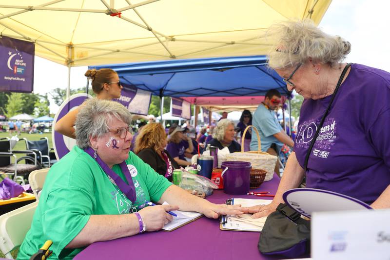 Debbie Caise, left, a 29-year volunteer and 28-year cancer survivor, greets a participant during the Relay for Life of Kankakee County on June 14, 2025, at The Grove in Bourbonnais.