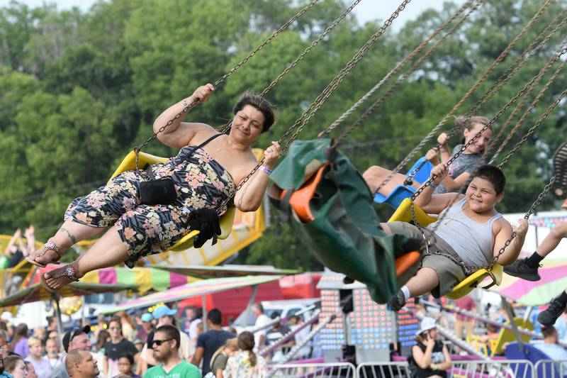 Lori Alcala of Dixon and her son Aiden, 8, ride the swings carnival ride at the Ogle County Fair on Saturday.