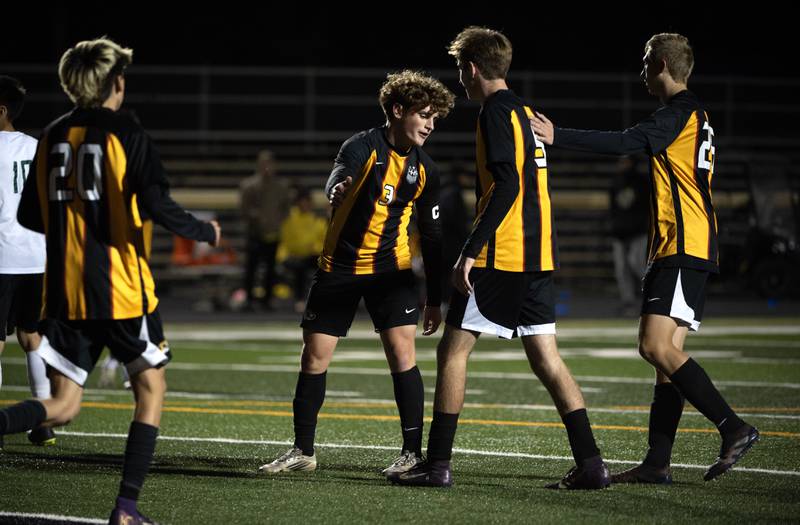 Herscher's Jacob Benoit, center left, and Kanden Venckauskas, center right, congratulate teammate Rowan Keigher, center, on his goal in a regional match-up with Bishop McNamara on Tuesday, October 21, 2025.