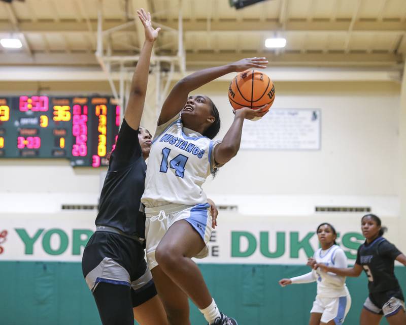 Downers Grove South's Ionna Griffin (14) puts up a shot over Oswego East's Jaliyah Shepard (20) during their York Thanksgiving Tournament matchup between Oswego East at Downers Grove South Friday, Nov 20, 2025 in Elmhurst.