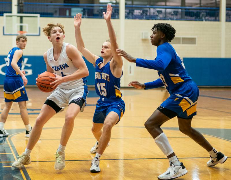 Geneva’s Tanner Dixon (4) plays the ball in the post against Wheaton North's Alex Nazar (15) and Jalen Crues (33) during a basketball game at Geneva High School on Friday, Jan 6, 2023.