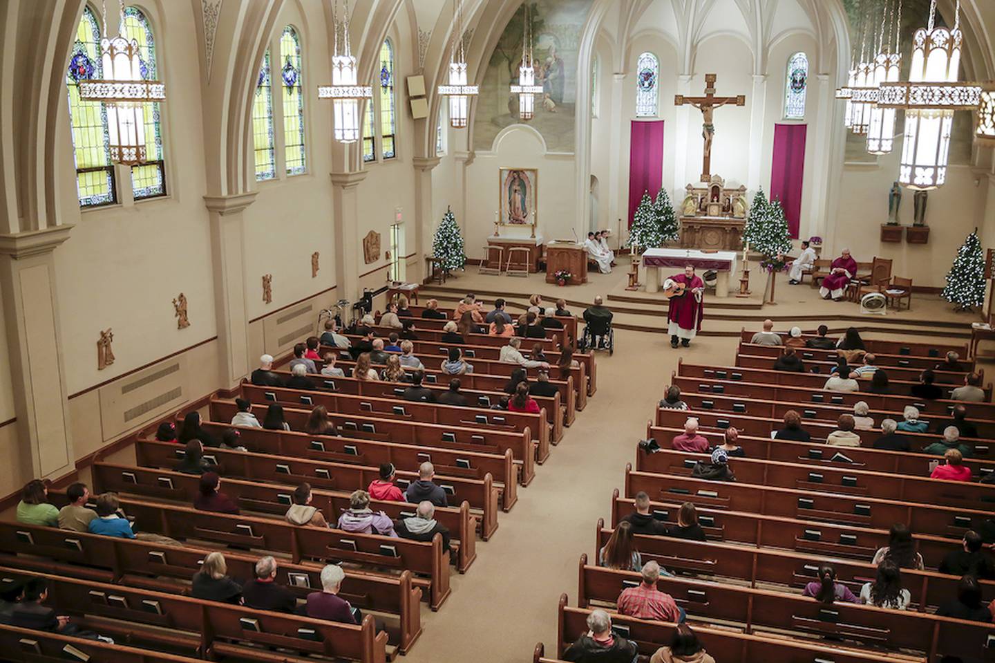 The Rev. Peter Jankowski plays a guitar during a Mass on Sunday at St. Patrick's Catholic Church in Joliet.