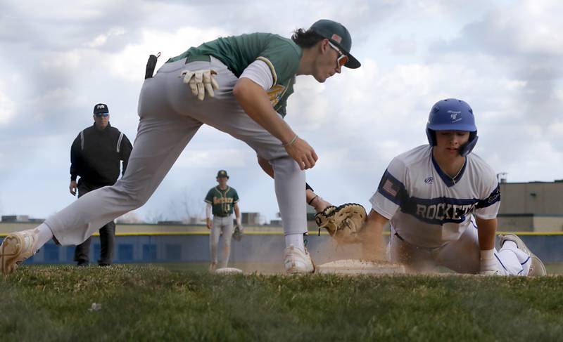 Burlington Central's Connor Finn safely dives back to first base as Crystal Lake South's C.J. Regillio tries to tag him during a Fox Valley Conference baseball game on Friday, April 12, 2024, at Burlington Central High School.