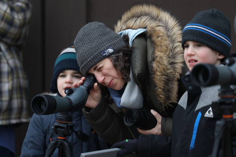 Rachel Revive, of Evanston, helps line up a spotting scope on an eagle for her sons Avi, left, and Eitan at the Four Rivers Environmental Education Center’s annual Eagle Watch program in Channahon.