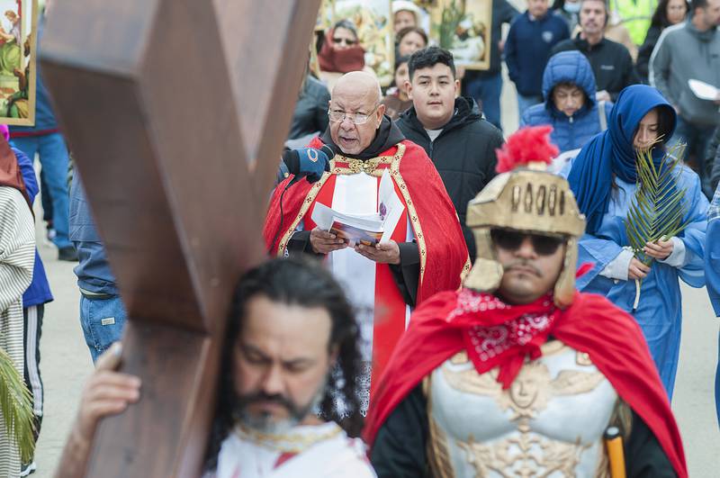 Father Carlos Monsalve reads prayers on Good Friday, April 15, 2022 during the second station of the cross, where "Jesus is made to carry the cross."