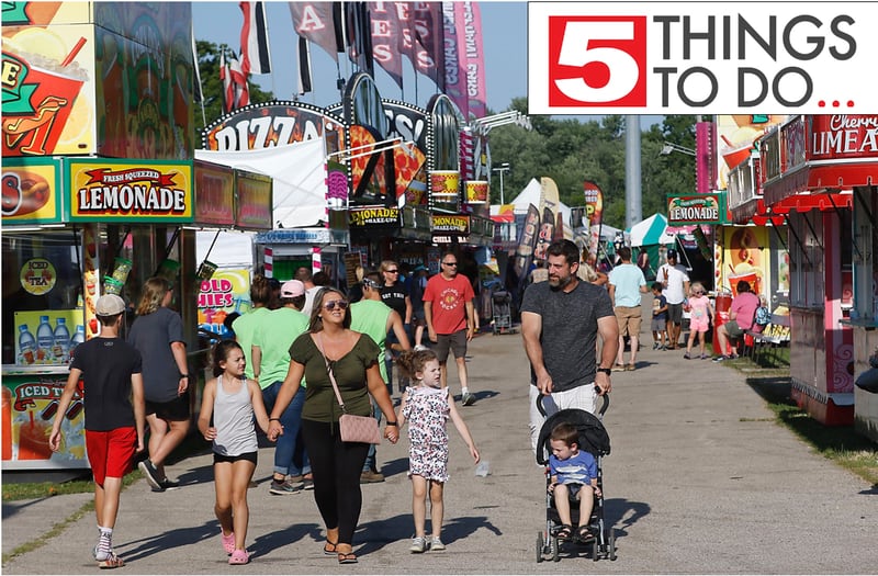 A family walks down the midway during the first day of the McHenry County Fair Tuesday, Aug. 2, 2022, at the fairgrounds in Woodstock. The fair runs through Sunday, Aug. 7. Entry to the fair is $10 for anyone over age 14, and $5 for children ages 6 to 13. Ages 5 and under are free.
