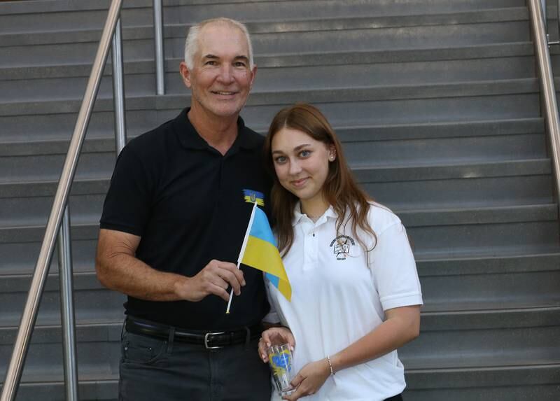 Anna Rudemko a refugee from Ukraine poses with Jim Gamache St. Bede alumnus while holding the Ukraine flag on Thursday, Aug. 31, 2023 at St. Bede Academy. Rudemko is a student at St. Bede who wanted to come to a school that she could feel welcome and exceed while her country is at war with Russia.