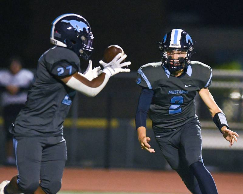 Downers Grove South’s William Potter, right, passes the ball to teammate Deon Davis (27) during the game Friday Sep. 15, 2023, as they took on Willowbrook in Downers Grove.