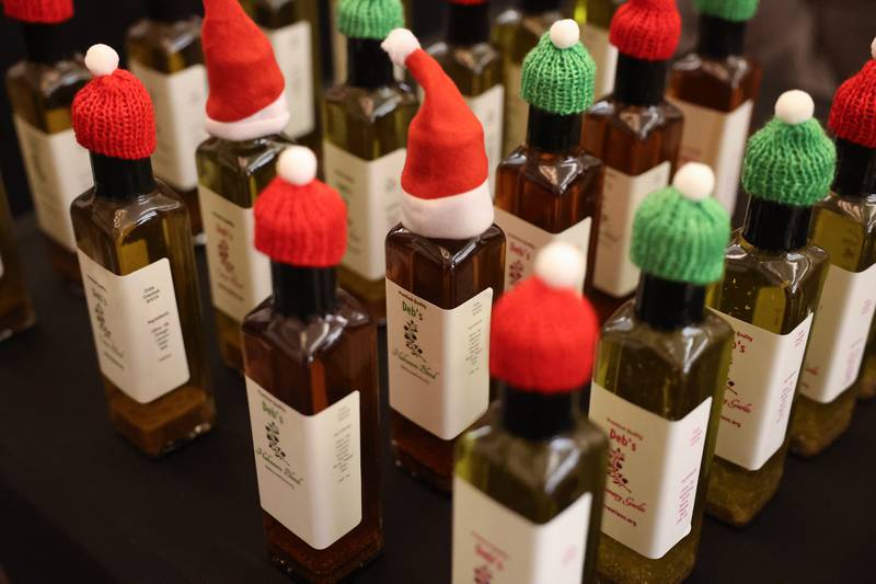 Holiday caps sit atop Deb’s Creations’ organic olive oils at the North Pole Christmas Market inside the Renaissance Center at the Joliet Light Up the Lights Holiday Festival on Friday, Nov. 29, 2024.