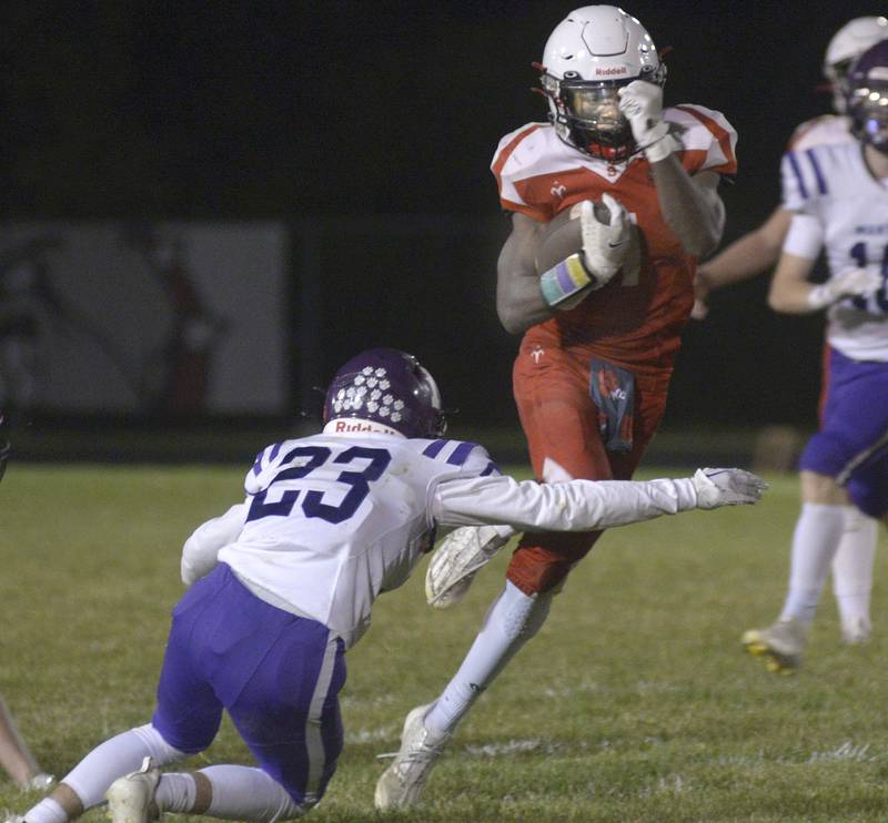 Streator’s Isaiah Brown leaps over the arm of Manteno’s Tyson Codi on a run in the 2nd quarter Friday at Streator.
