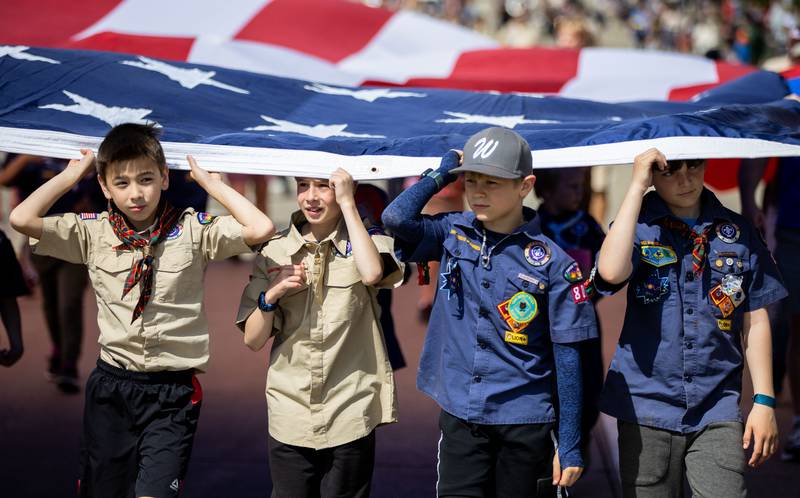 Scouts march with an American Flag during the St. Charles Memorial Day Parade in downtown St. Charles on Monday, May 26, 2025.