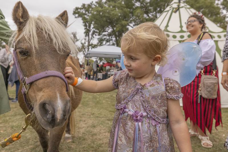 Lianna Rust pets a pony Saturday, Sept. 28, 2024, during the Cedar Creek Ranch Renaissance Faire at Cedar Creek Ranch.