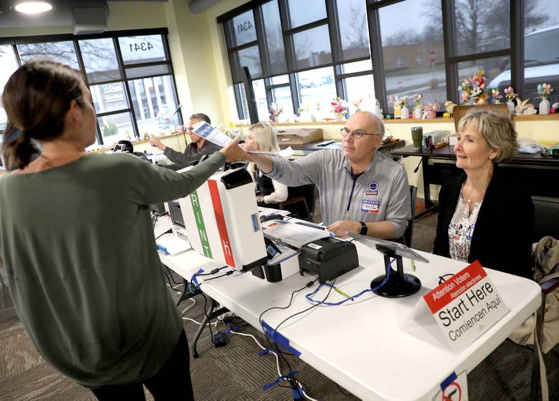 Election Judges Paul Horvatin and Anne Wick help voter Lindsay Frost of Downers Grove during the Consolidated Election at the Downers Grove Township offices polling place on Tuesday, April 3. 2023.