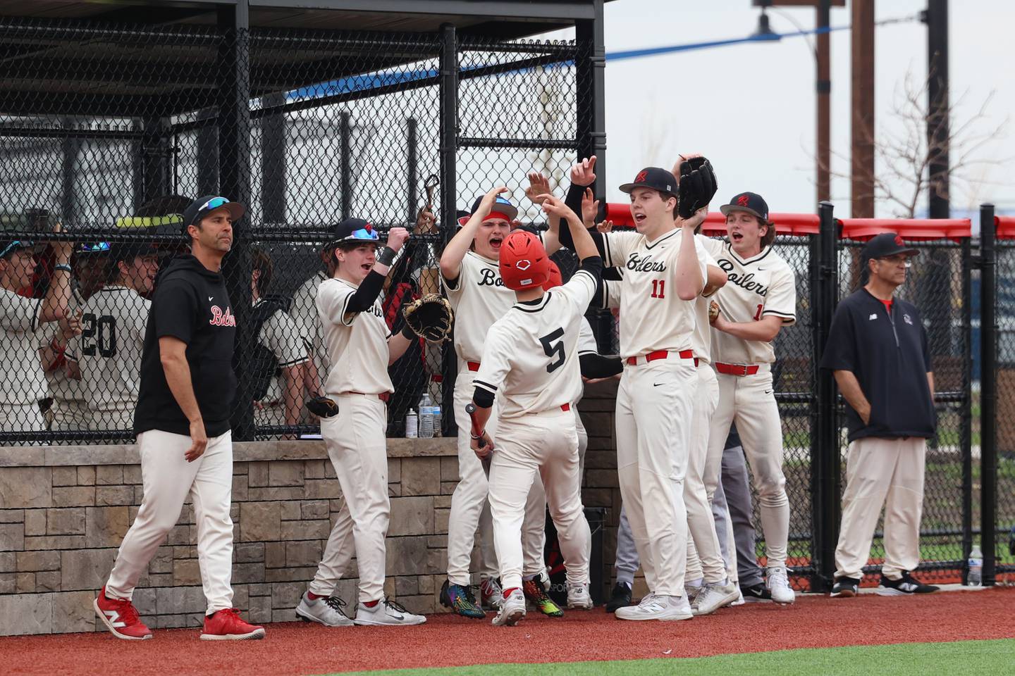 Bradley-Bourbonnais' Jace Boudreau (5) celebrates scoring a run with teammates to pull ahead by two runs in the third inning during the Boilermakers' 8-7 loss to Homewood-Flossmoor on Monday, April 13, 2026.