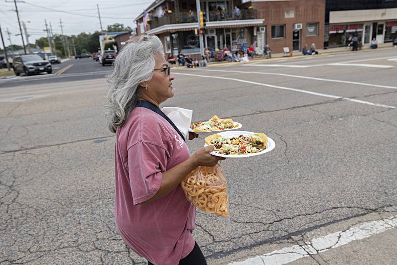 Theresa Milne of Rock Falls carries plates of food Saturday, Sept. 16, 2023 at the start of the Fiesta Days parade.
