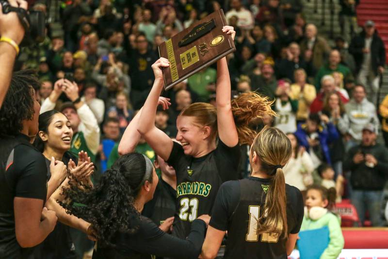 Waubonsie Valley's Lily Newton (23) holds the plaque while celebrating with teammates after their win in their Class 4A Bolingbrook Sectional final basketball game between Waubonsie Valley at Benet. Feb 27, 2025 in Bolingbrook.