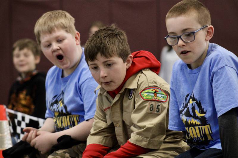Webelos, from left, Grant Haveland, Tim Thrasher and Owen Dempsey react as their pinewood derby cars race down the track toward the finish line on Saturday, Feb. 11, 2023, at Bethel Evangelical Congregational Church in Dixon.