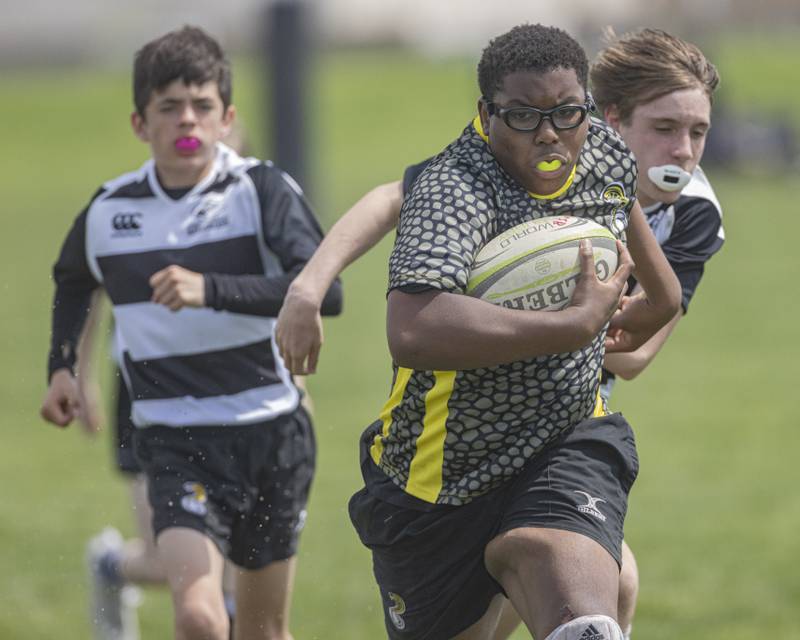 Ryan Harris of the South Suburban Cobras Rugby Club evades defenders and runs the ball into the try zone, scoring the try and awarding his team five point during the game at Veterans Park on April 28, 2024.
