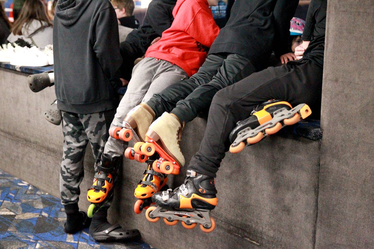 Kids hang out on a bench during a winter break open skate session at Funway in Batavia.