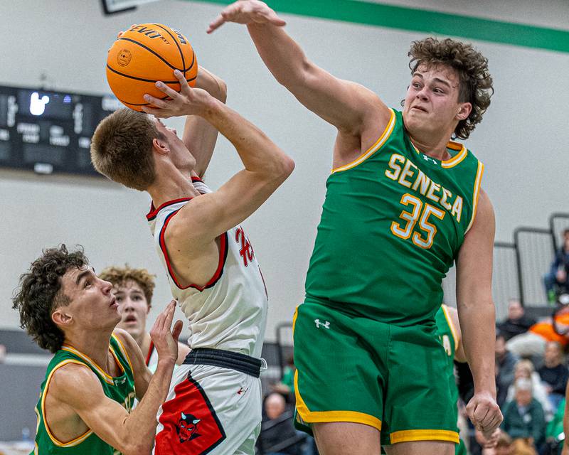 Luke Bryant (4) of Hall attempts to lay ball up as Zeb Maxwell (35) of Seneca attempts to block shot during game in the Shipyard Showdown on Tuesday, December 23, 2025 at Seneca High School in Seneca.