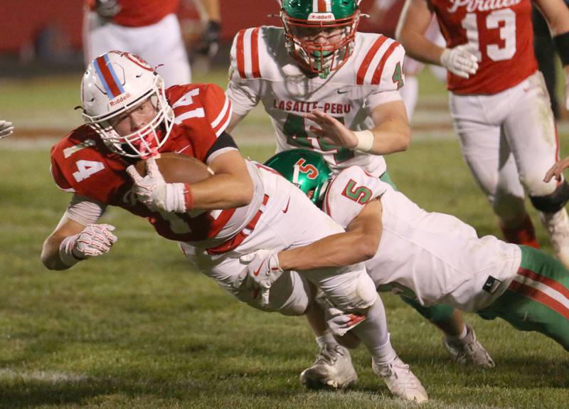 Ottawa's Archer Cechowiz is brought down by L-P's Reagan Doerr and teammate Caedan Small (top) on Friday, Sept. 12, 2025 at King Field.