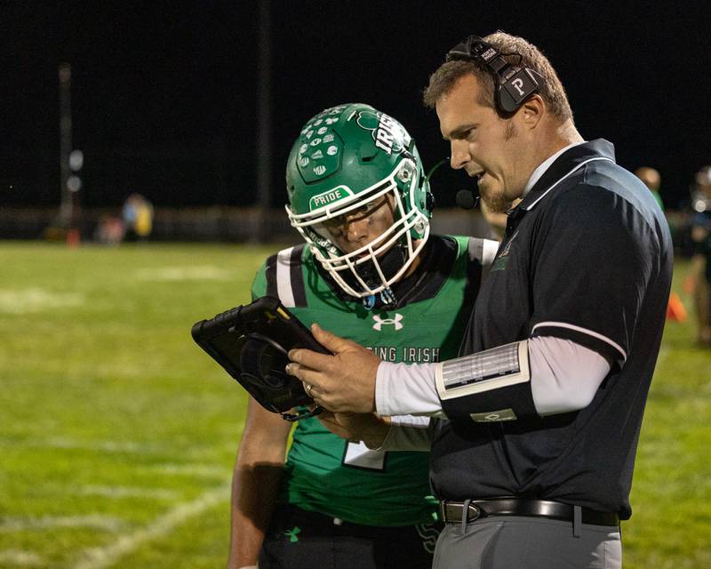 Seneca Head Coach Terry Maxwell, shows Ethan Othon (1) of Seneca play on tablet on Friday, Oct. 10, 2025 at Seneca High School in Seneca.