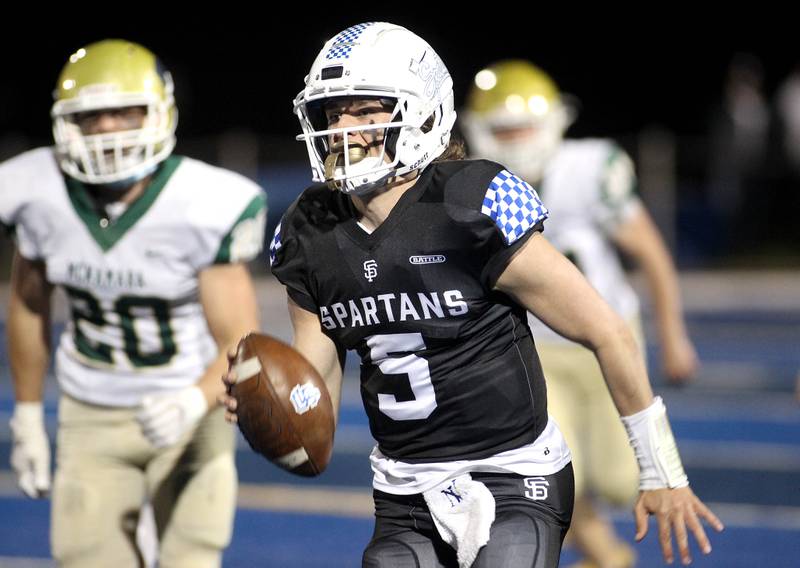 St. Francis quarterback Tommy Rittenhouse (5) keeps the ball during a home game in Wheaton against Bishop McNamara on Friday, April 23, 2021.