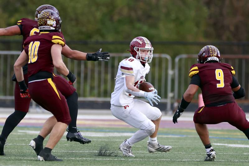 Morris' Logan Conroy (18) looks to evade a host of Montini players during the IHSA Class 4A semifinals football playoff game Saturday, Nov. 22, 2025 in Lombard.