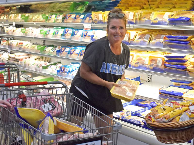 Michelle Duttlinger of Ottawa, loads chicken breasts into her cart during the Hometown National Bank “Hometown Hero” sweepstakes on Friday, Aug. 23, 2025 at Hy-Vee in Peru. Duttlinger was the winner of the shopping spree.