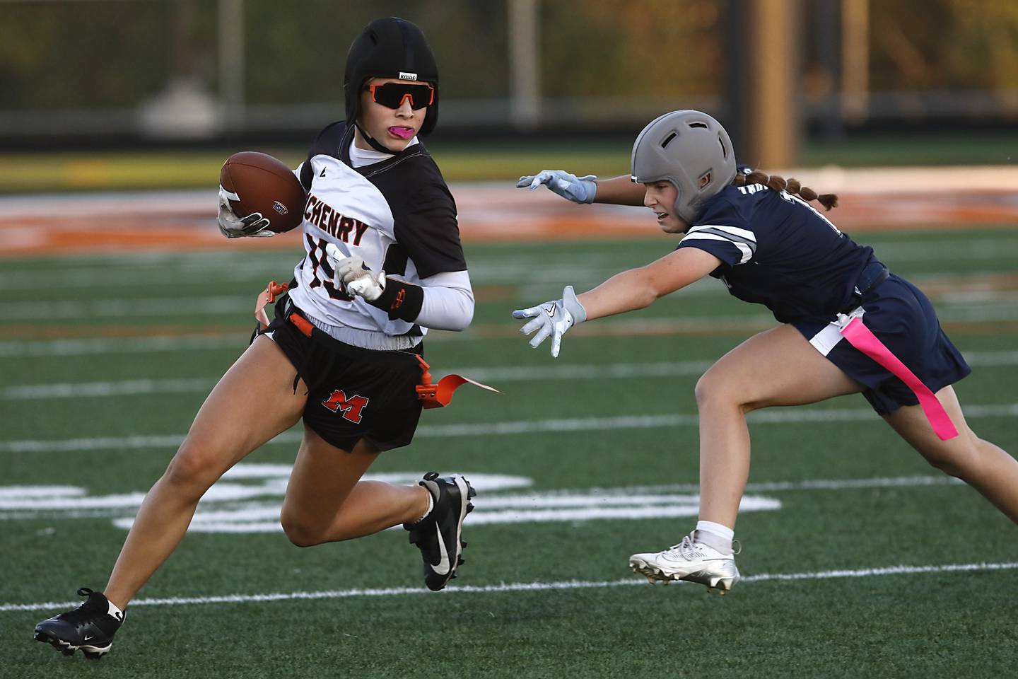 McHenry's Addison Hoffman runs away from Cary-Grove's Taylor Allen during the IHSA McHenry Regional girls flag football championship game on Wednesday, Oct. 8, 2025, at McCracken Field in McHenry.
