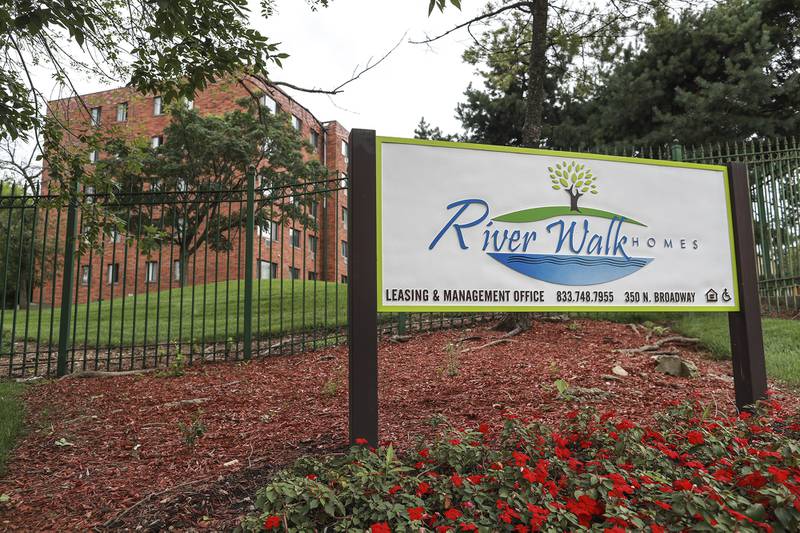A welcome sign sits outside of Riverwalk Homes on Tuesday, July 13, 2021,  in Joliet, Ill. Holsten Development, the company that manages Riverwalk Homes, will begin demolishing some of the buildings beginning in 2022, as part of a project to reduce the number of units on site from 356 to 177 by 2025