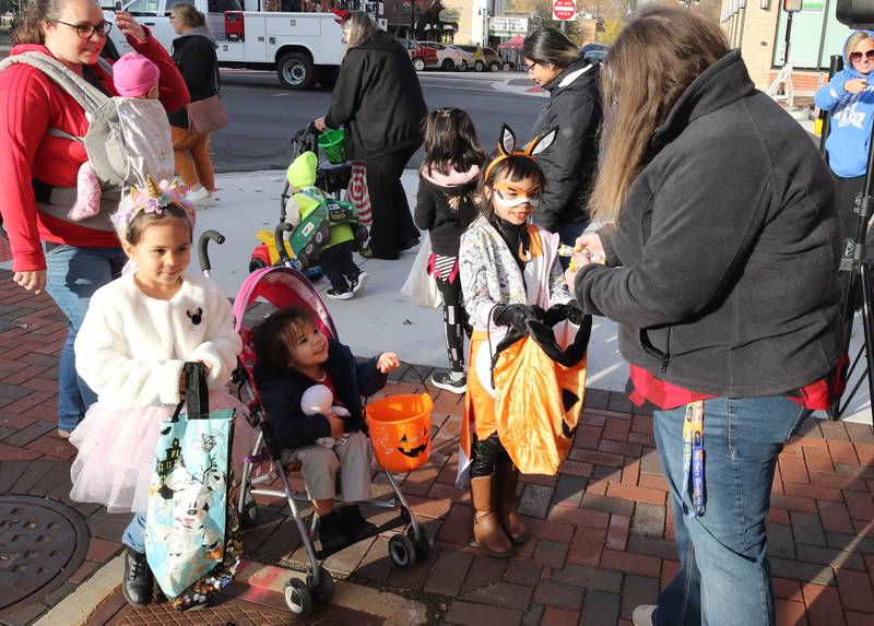 Trick-or-treaters stop by the WDKB table for some treats in downtown DeKalb Thursday, Oct. 27, 2022, during the Spooktacular trick-or-treating event hosted by the DeKalb Chamber of Commerce.